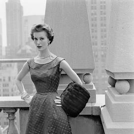 A Model Standing Against A Rooftop Column In An by Richard Rutledge