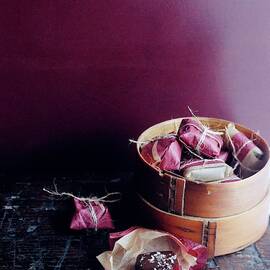 A Bamboo Steamer With Paper Packages by Romulo Yanes