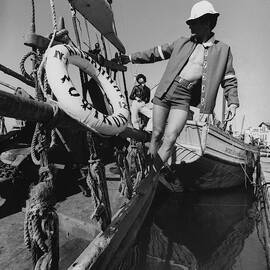 A Male Model Posing In A Boat Wearing A Cotton by Leonard Nones