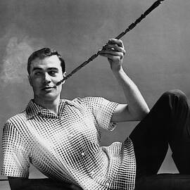A Male Model Smoking A Cigarette From A Long Pipe by Emme Gene Hall