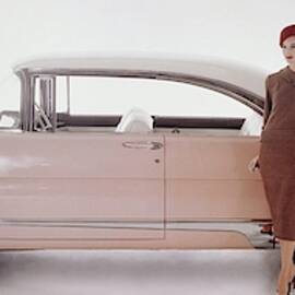 A Model Posing In Front Of A Vintage Car by Karen Radkai