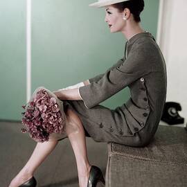 A Model Sitting Down With A Bouquet Of Flowers by Karen Radkai