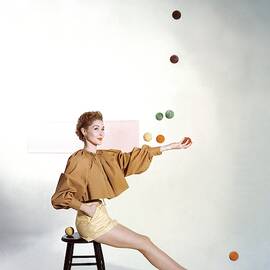 A Model Sitting On A Stool Juggling by John Rawlings