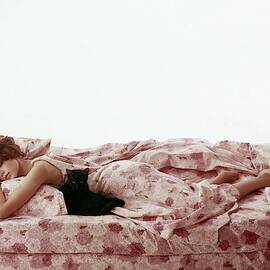 A Model Sleeping On Floral Bed Linens by Karen Radkai