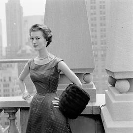 A Model Standing Against A Rooftop Column In An by Richard Rutledge