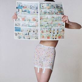 A Model Wearing A Girdle With A Comic by Louis Faurer