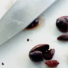 A Sharp Knife And A Group Of Olives by Romulo Yanes