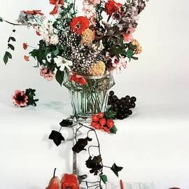 A Studio Shot Of A Vase Of Flowers And A Garden by Herbert Matter