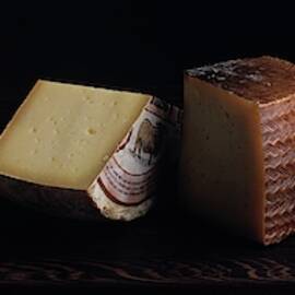 A Variety Of Cheese On A Cutting Board by Romulo Yanes