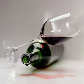 A Wine Bottle And A Glass Of Wine by Romulo Yanes