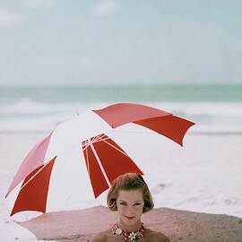 A Woman Buried In Sand At A Beach by Richard Rutledge