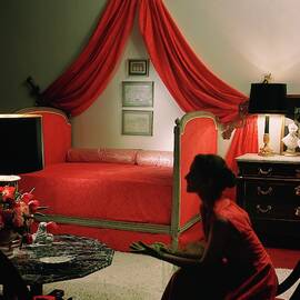 A Young Woman Sitting In A Red Bedroom by Horst P. Horst