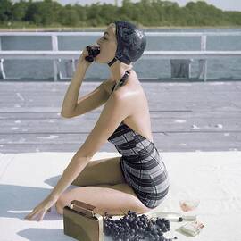 A Young Woman Wearing A Swimsuit Eating Grapes by John Rawlings