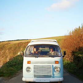 Couple Driving Camper Van Along Coastal by Dougal Waters