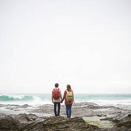 Couple Holding Hands And Looking Out To by Dougal Waters