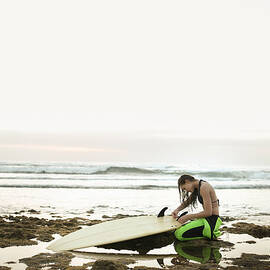 Girl Preparing Surfing Board On Rocky by Stanislaw Pytel