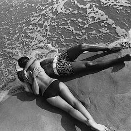 Models Embracing On A Beach by Mark Patiky