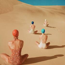 Models Sitting On Sand Dunes by Clifford Coffin