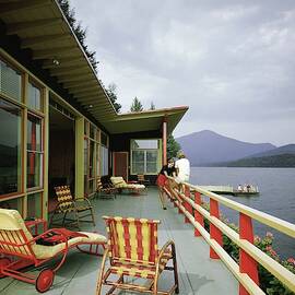 Two Women On The Deck Of A House On A Lake by Robert M. Damora