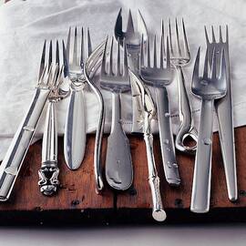 Various Forks On A Wooden Board by Romulo Yanes