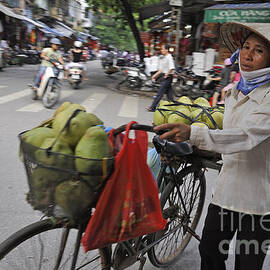 Woman carrying fruit on bike by Sami Sarkis Photography