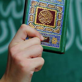 Boy's hand holding Koran by Sami Sarkis Photography