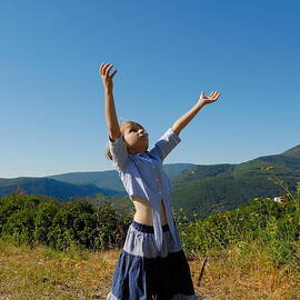 Girl playing with balloon in meadow by Sami Sarkis Photography