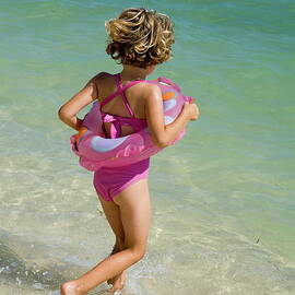 Girl running into water on beach by Sami Sarkis Photography