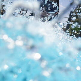 Girl splashing water in swimming pool by Sami Sarkis Photography