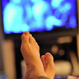 Man watching television feet up by Sami Sarkis Photography