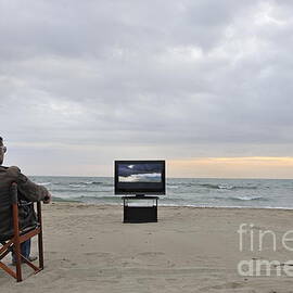 Man watching TV on beach at sunset by Sami Sarkis Photography