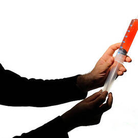 Man's silhouette holding  a  big syringe by Sami Sarkis Photography