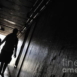 Mother and daughter walking in a dark corridor by Sami Sarkis Photography