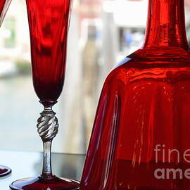 Red glasses on shelves in Murano by Sami Sarkis Photography