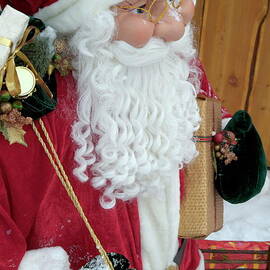 Santa Claus toy standing next to Christmas presents by Sami Sarkis Photography