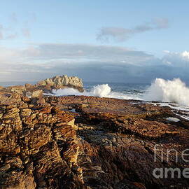 Waves breaking on rocky shore at sunset by Sami Sarkis Photography