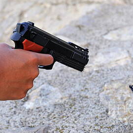 Woman pointing a toy gun on butterfly by Sami Sarkis Photography
