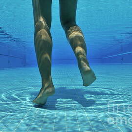 Woman's legs on pool floor by Sami Sarkis Photography