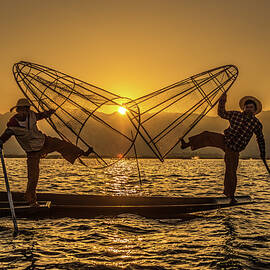 Burmese fishermen on bamboo boats at sunrise by Miroslav Liska