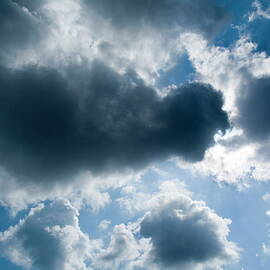 Clouds floating across a blue sky by Sami Sarkis Photography