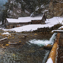 Old wooden water mill in winter with snow falling by Miroslav Liska