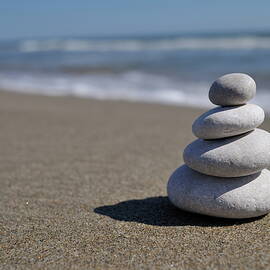 Stack of pebbles on beach by Sami Sarkis Photography