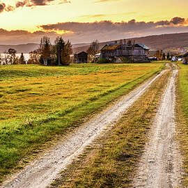 Wooden barn with farmhouse at sunset in Norway by Miroslav Liska