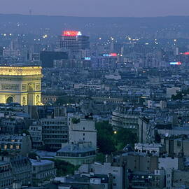 Arc de Triomphe illuminated at twilight surrounded by the cityscape of Paris by Sami Sarkis Photography