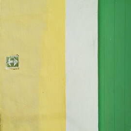 Arrow sign on a building next to a green door on a street in Trinidad by Sami Sarkis Photography