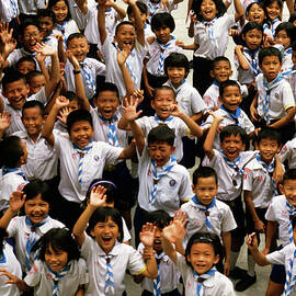 Bangkok school children jumping and smiling at the camera by Sami Sarkis Photography