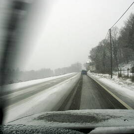 Car driving on a snowy road in the winter by Sami Sarkis Photography