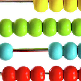 Closeup of bright  abacus beads on white by Sandra Cunningham
