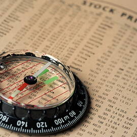 Compass on stockmarket cotation in newspaper by Sami Sarkis Photography