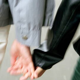 Couple holding hands while strolling down the street by Sami Sarkis Photography
